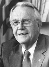 A black-and-white portrait of a man in his fifties wearing a suit