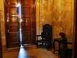 A marble-walled room with a chair and wooden door