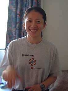 Yang Yang inside a hotel, looking at the camera and smiling.