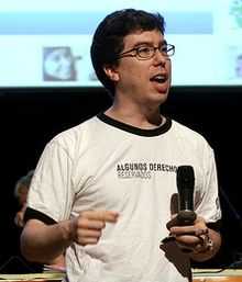 waist high portrait wearing a T-shirt and holding a microphone