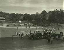 A baseball field with people and a band gathered