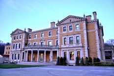 A three-story beige Renaissance Revival mansion