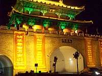 A picture of a modern-day reconstruction of a Bianjing city gate, in Bianjing's old town. The guard tower above the gate is wide and has two stories, different from the historical depictions.