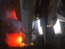 The video starts with a view of the NASA and Space Shuttle program logos followed by titles. The first view is of the base of a Space Shuttle stack as seen from a camera mounted above on the External Tank. White vapour can be seen curling around the base of the shuttle. The view cuts to a wide shot of the launchpad, before moving back to the original view, at which point large jets of water can be seen pouring into the flame trench beneath the shuttle. The video then moves to a view from underneath the stack, showing the three RS-25 engines mounted in the orbiter in slow motion. Orange sparks begin to project from service structures either side of the engines, then the video changes to a quartered view, with shots of both sides of the engine cluster and a clock. The engines then ignite, in the sequence right, left, top. At first, the engines burn with a yellow flame, but the flames then progress through white and blue, eventually forming perfect cones with mach discs visible lower in the plume. A side view of this in real time is then shown, followed by a return to the original view where the real-time process repeats. The movement of the top of the stack as this occurs is shown next, followed by the retraction of the umbilicals mounted either side of the orbiter's aft structure and to the external tank, the ignition of the shuttle's solid rocket boosters, and the liftoff of the stack. Several views of the first stage ascent, including SRB separation, are then shown. Next the view changes to a view from another external tank camera pointing aft, showing the engines' plume, in the form of a large white ring, glowing around the aft of the shuttle. This gradually fades as the engines throttle back and shut down, before the orbiter separates from the external tank, accompanied by bright thruster firings. Finally, the video fades and is replaced by another logo.