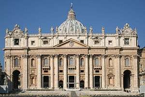 The façade, lit by floodlights, rises majestically against the night sky.