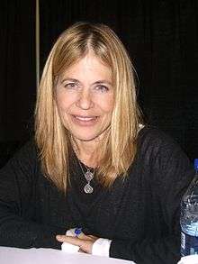 Portrait of lady with blonde straight hair wear black smiling at the camera