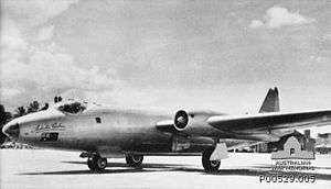 Twin-engined, straight-winged military jet, parked on airfield