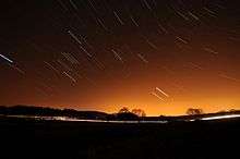 Short streaks of light on a dark sky, showing star trails that were photographed with a long exposure.