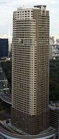 Aerial view of a brown and beige, rectangular, window-dotted high-rise