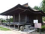 A wooden building with a wide front veranda.