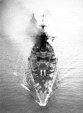 A black and white image of HMAS Australia about to pass under the Forth Bridge in Scotland.