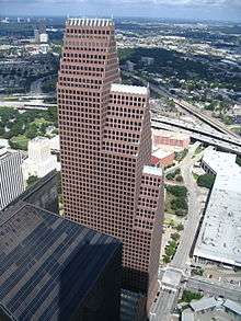 Large building with three, segmented tower setbacks, each with  a steeply pitched roof line topped with a series of spires.