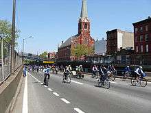 A freeway in a trench through an urban area, with a church visible in the background