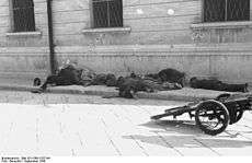 Bodies of uniformed men on a sidewalk