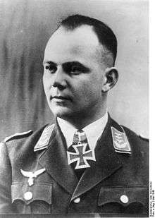 A man wearing a military uniform with an Iron Cross displayed at his neck.