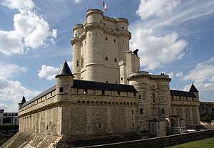 A tall stone tower surrounded by a shorter square wall.