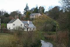 Houses and fields be3side a country lane.