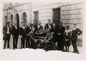 outdoor group photograph of a small class of students with their professor