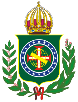 Coat of arms consisting of a shield with a green field with a golden armillary sphere over the red and white Cross of the Order of Christ, surrounded by a blue band with 20 silver stars; the bearers are two arms of a wreath, with a coffee branch on the left and a flowering tobacco branch on the right; and above the shield is an arched golden and jeweled crown