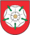 A coat of arms depicting a white flower in the middle that has a yellow stamen and green leaves all on a red background