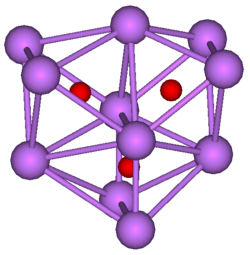 The ball-and-stick diagram shows three regular octahedra where each octahedron is connected to both of the others by one face each. All three octahedra have one edge in common. All eleven vertices of the structure are violet spheres representing caesium, and at the centre of each octahedron is a small red sphere representing oxygen.