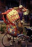 Cycle rickshaw wallah and rickshaw, Dhaka.jpg