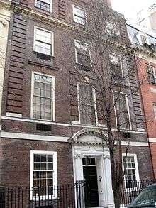  A brownish brick townhouse with stone trim