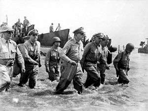 Douglas MacArthur and troops wading ashore in thigh-deep water