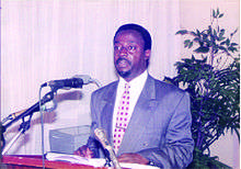 Man standing at a podium in front of microphones