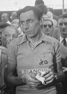 A black and white photo of a man in front of a crowd of people