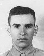 A head and shoulders portrait of a young, cleanshaven man with dark hair.