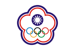 A white symbol in shape of a five petal flower ringed by a blue and a red line. In its center stands a circular symbol depicting a white sun on a blue background. The five Olympic circles (blue, yellow, black, green and red) stand below it.