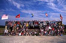 A chainlink fence covered in mementos and flags  dedicated to the flight 93 crash