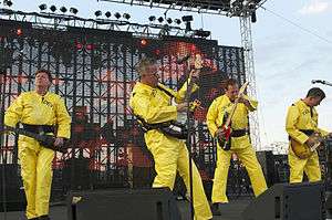 Devo onstage in their trademark bright yellow costumes