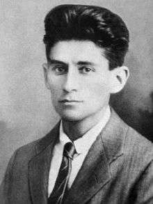 Black-and-white photograph of Kafka as a young man with dark hair in a formal suit