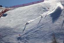 Skier and guide skier skiing down a mountain