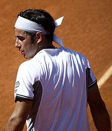 Frederico Gil, with his back turned to the photographer, looks back to receive his towel.