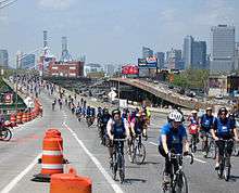 An elevated freeway in a city with bicyclists riding on it