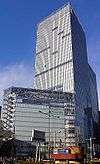 Ground-level view of a glass, rectangular high-rise