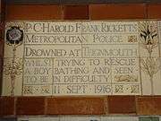 A tablet formed of five tiles of varying sizes, bordered by yellow and blue flowers in an art nouveau style