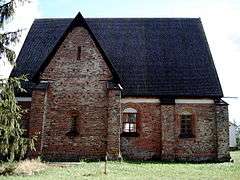 Brick building with steep roof and Gothic windows