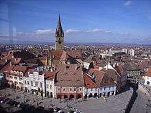 A square with medieval buildings and a tower