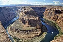 View of a rocky canyon with a blue river curving around a large bluff