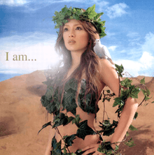 Ayumi Hamasaki shown from the waist up, looking outward with her hands on her waist, wearing only foliage, with a dove resting on her left shoulder. In small text, "I Am..." is written on the left side.