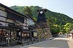 Wooden houses and a wooden clock tower on a stone base.