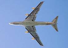 Underside view of an in-flight 747. Under each of the two wings are two engines.