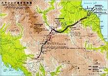 A colour map depicting the Japanese advance south from Buna along the Kokoda Track and over the Owen Stanley Range. The map has both Japanese and English characters on it and Japanese movements are depicted in black arrows, while locations of battles are depicted by breaks in the line and red arcs