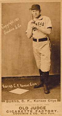 A baseball player is standing, holding a baseball bat.