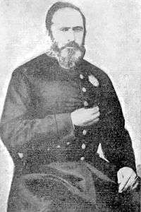 Half-length photographic portrait of a bearded man wearing a dark military tunic