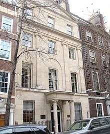  A light tan stone townhouse with an entrance portico